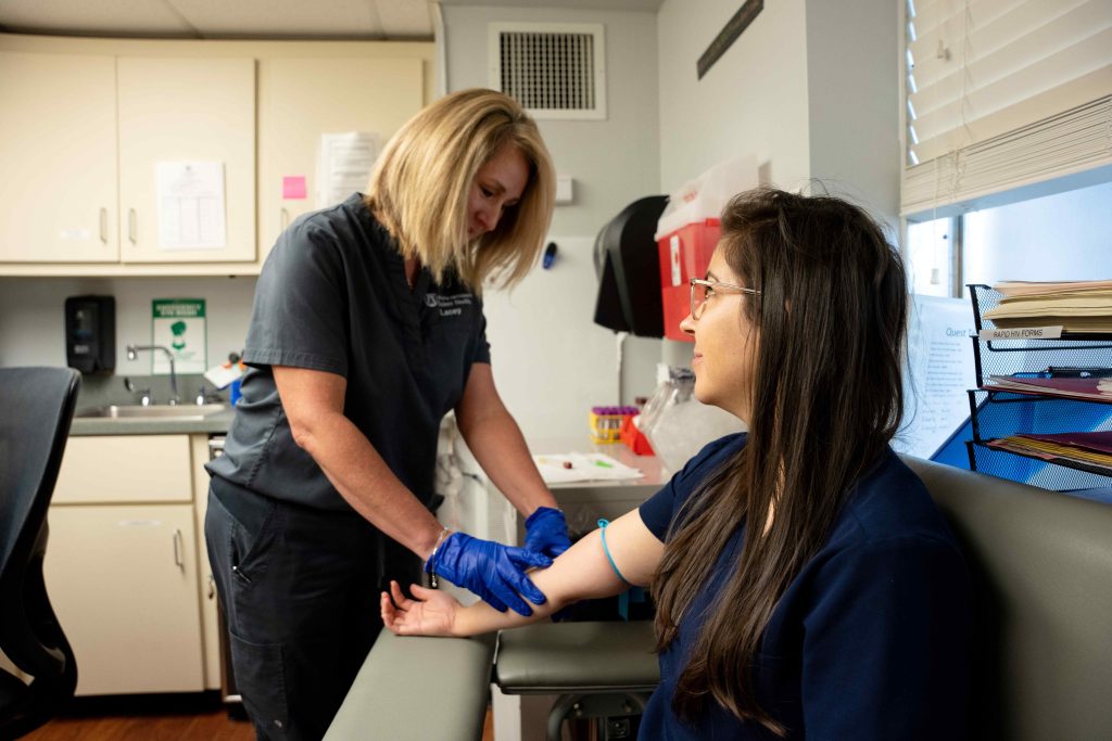 A health care worker draws a patient's blood.