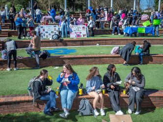 A group of students sit outdoors.