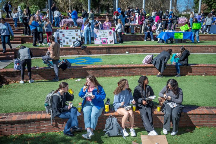 A group of students sit outdoors.