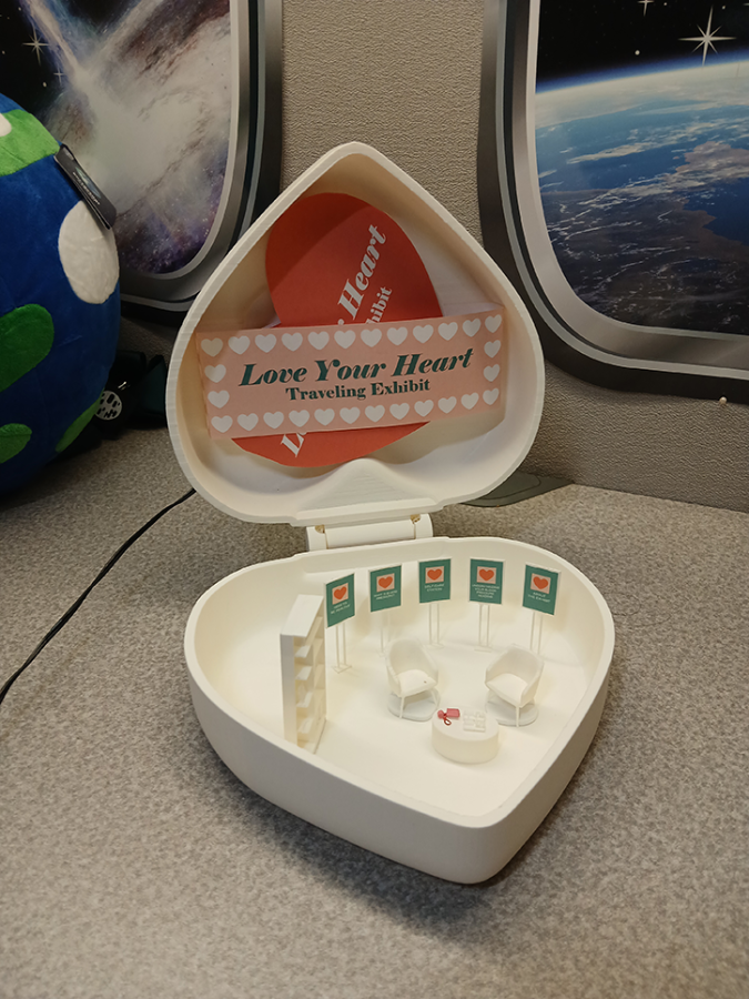 Miniature heart box with doll-sized furniture and posters inside.
