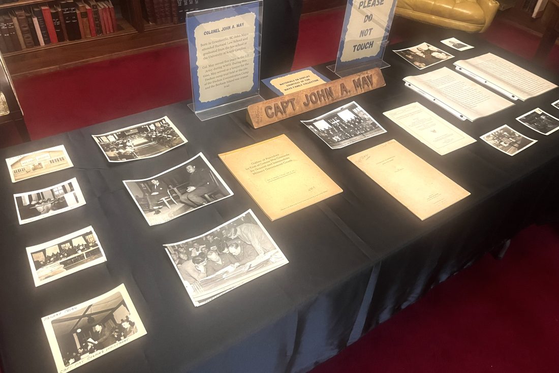 A table filled with documents related to the trials surrounding the Dachau Concentration Camp.