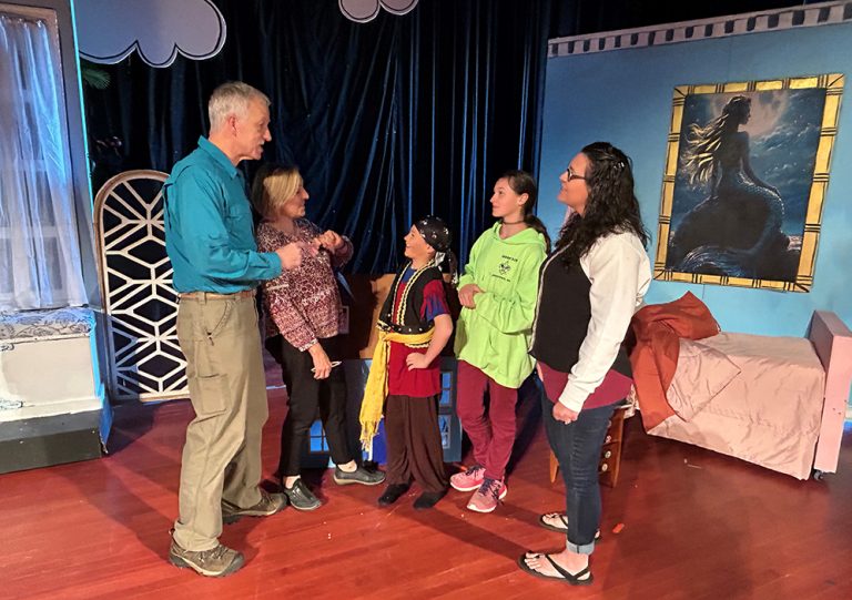 Man and woman talking with children and an adult woman