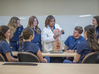 Female professor talking to students with a diagram