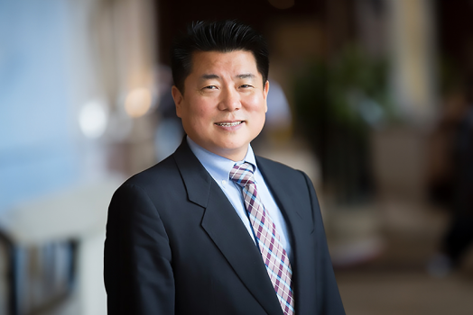 A man in a suit and tie stands in a hallway.
