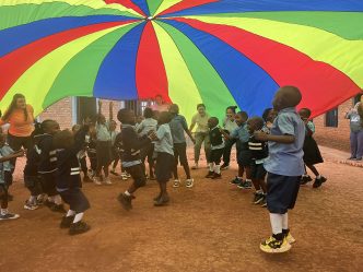 Children playing under a colorful tarp