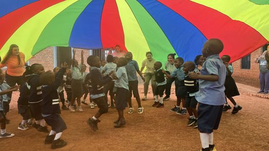 Children playing under a colorful tarp