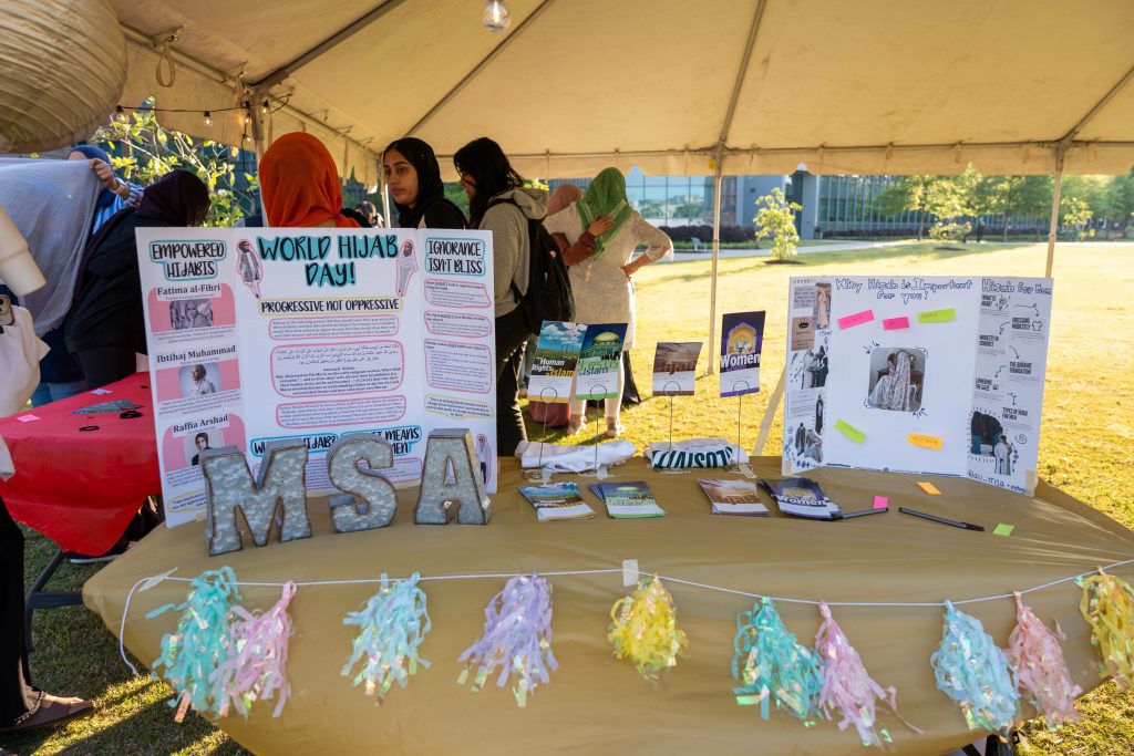 Various materials providing information on a student organization presented on a table at an outdoor event.
