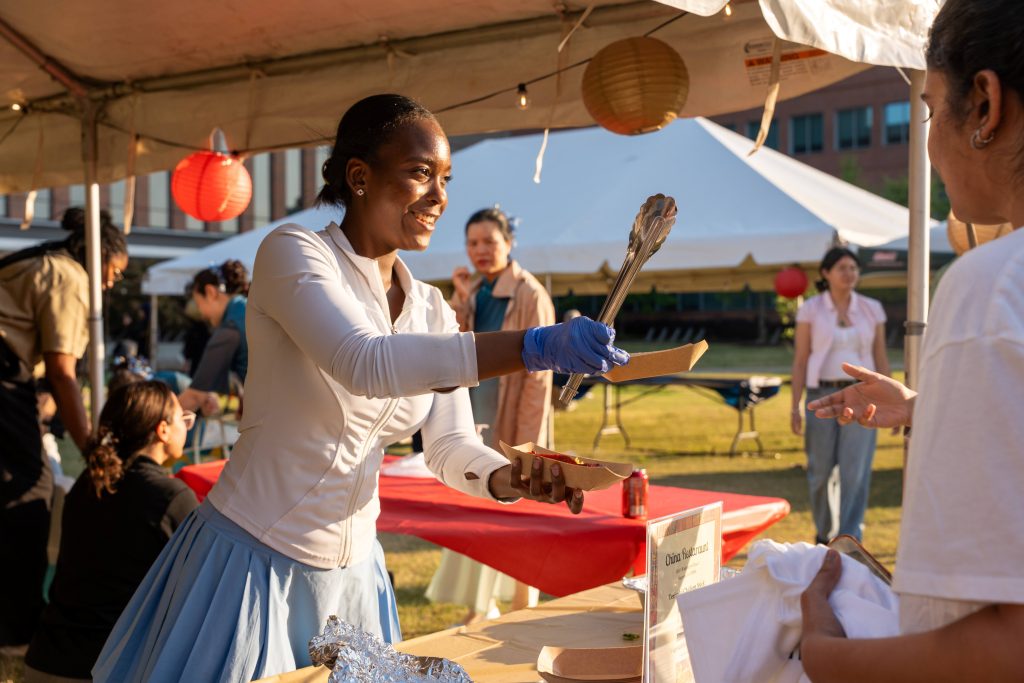 A woman hands someone food.
