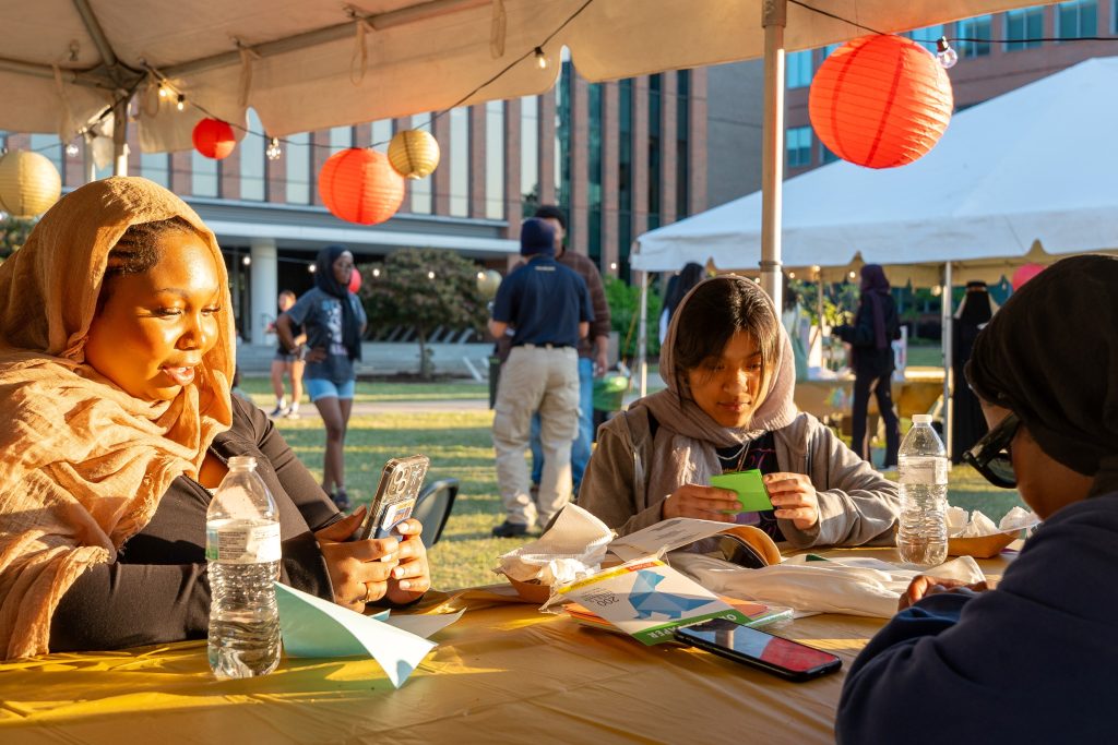 Three students sit at a table.