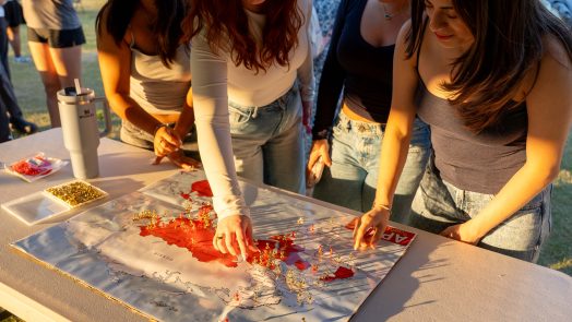 Several women place pins on a map.