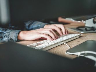 hands typing on a computer