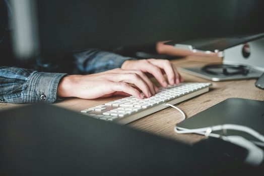 hands typing on a computer
