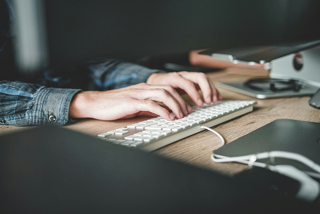 hands typing on a computer