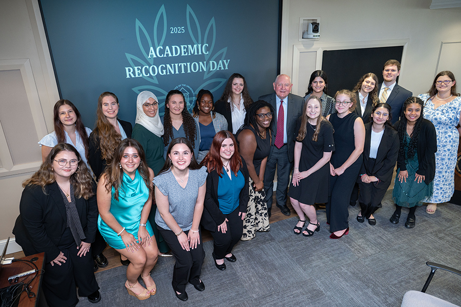 A large group of college students gather in a large conference room during a special ceremony.