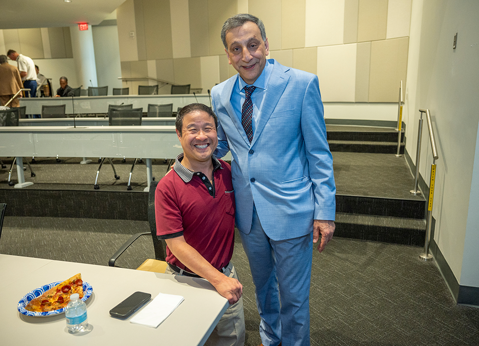 Two dental college faculty members pose for a picture together.