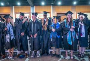 College graduates in caps and gowns celebrate turning their tassels from right to left to signify they have officially graduated.