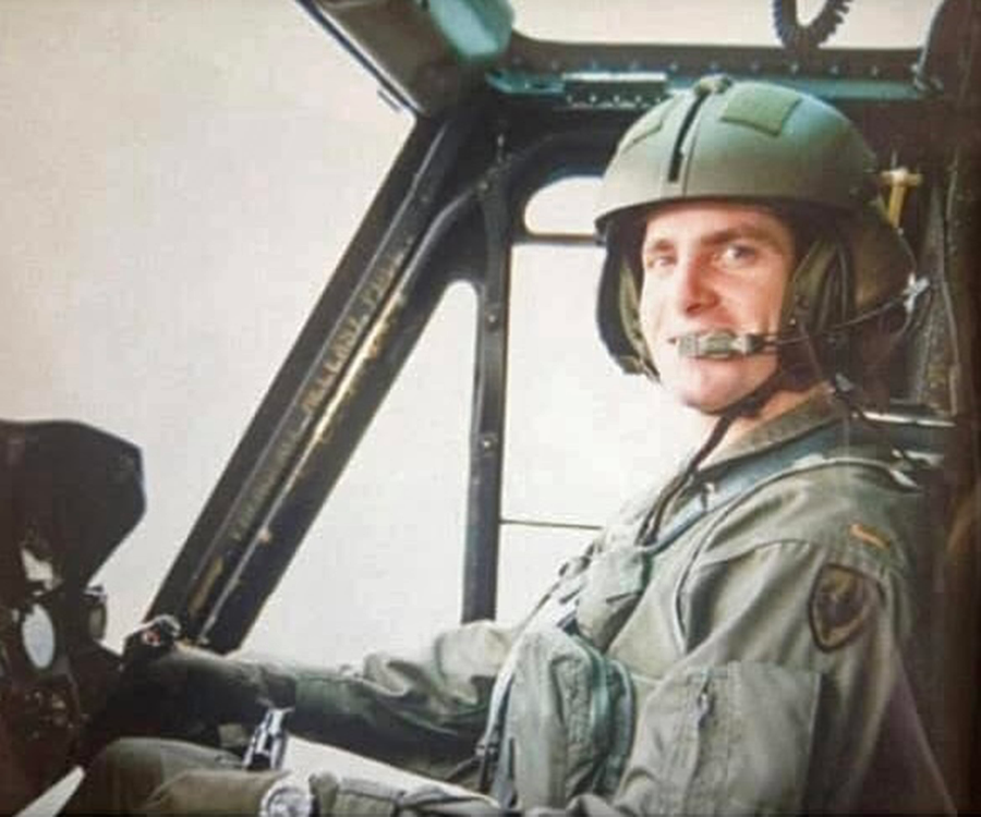 An Army pilot at the controls of a helicopter.