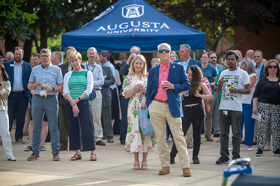 A large group of people are gathered during an event on a college campus.