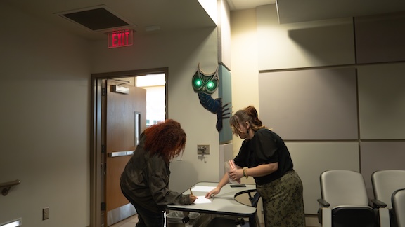 A college student checks in for a special event held in a classroom.