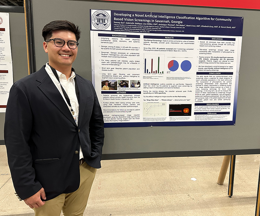 A man stands next to a scientific poster hanging on a stand.