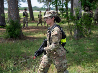 A female soldier holds a training rifle during an exercise.