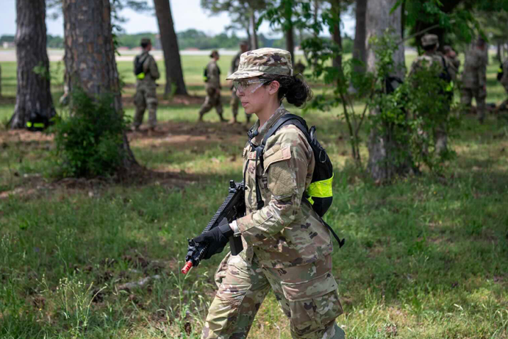 A female soldier holds a training rifle during an exercise.