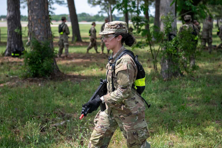 A female soldier holds a training rifle during an exercise.