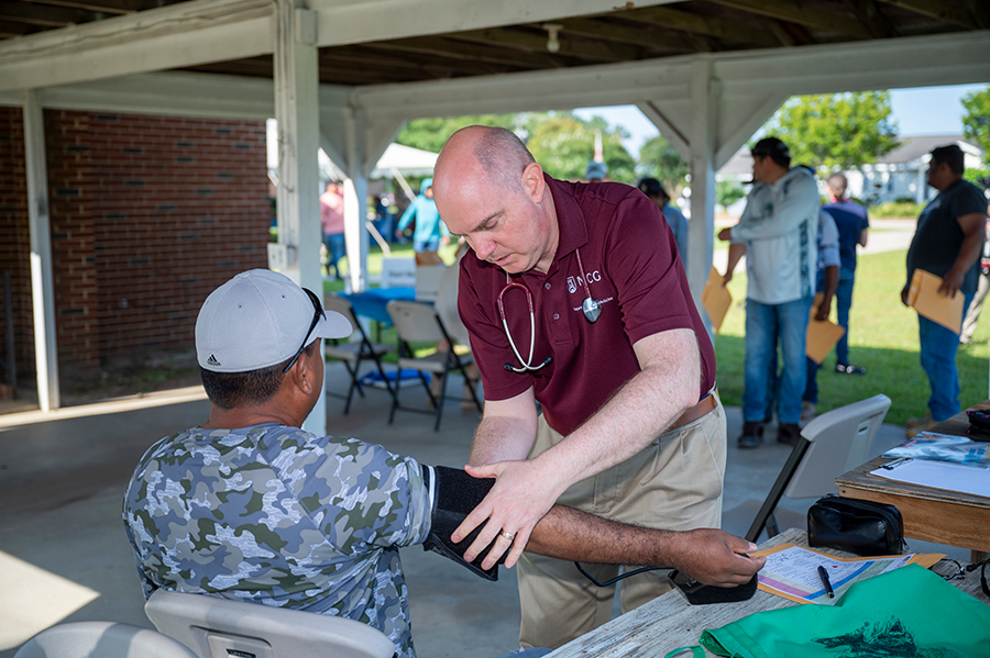 A healthcare worker checks the blood pressure of a patient.