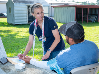 A healthcare worker interviews a patient during a rural health clinic.