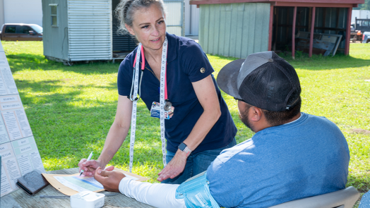 A healthcare worker interviews a patient during a rural health clinic.