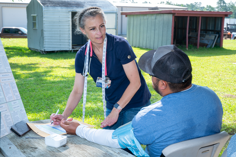 A healthcare worker interviews a patient during a rural health clinic.