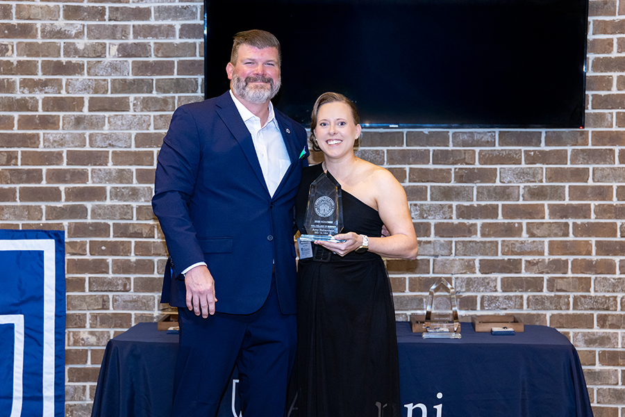 A man presents a woman with a special award during a big ceremony.