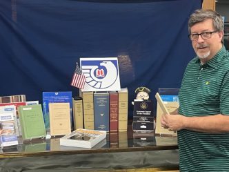 Man stands next to set of books about government
