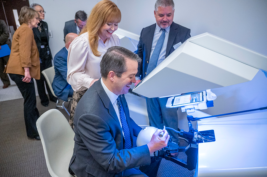 A man learns how to use a special teaching tool that simulates cleaning teeth on a patient.