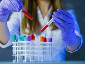 Scientist in lab with test tubes