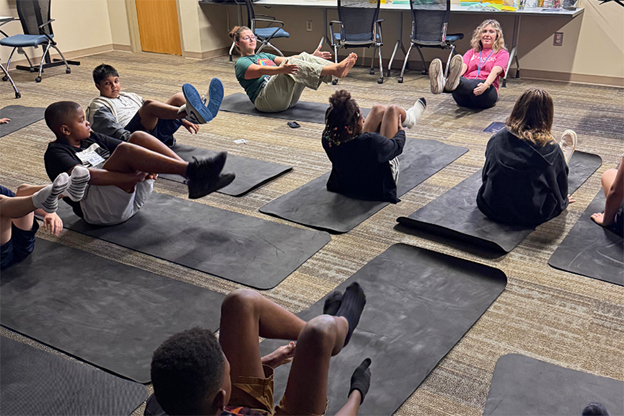 Elementary-aged children participate in yoga during a summer camp.