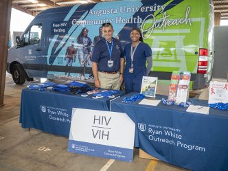 Man and woman smiling in front of a van