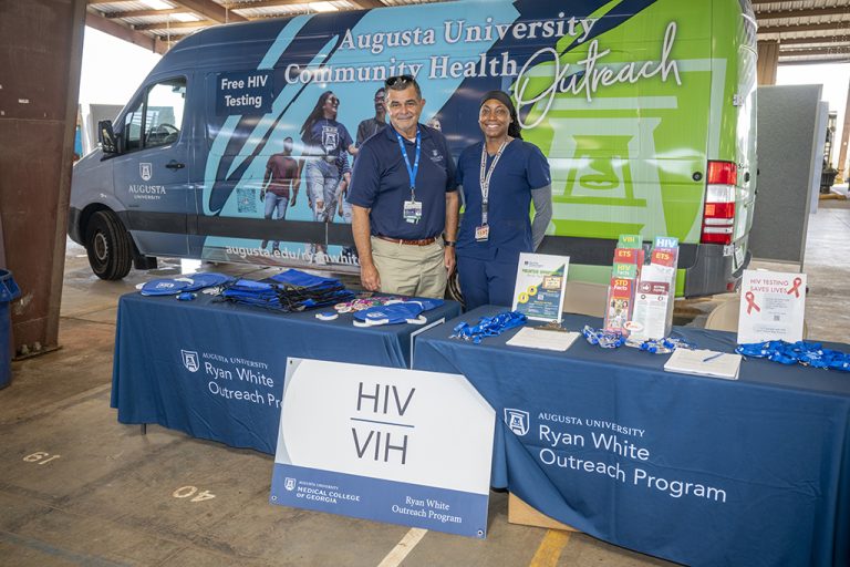 Man and woman smiling in front of a van