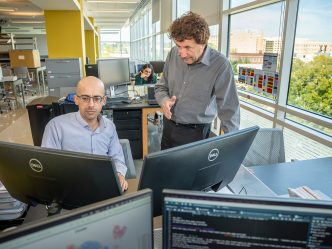 Two men at computers in a modern science lab.