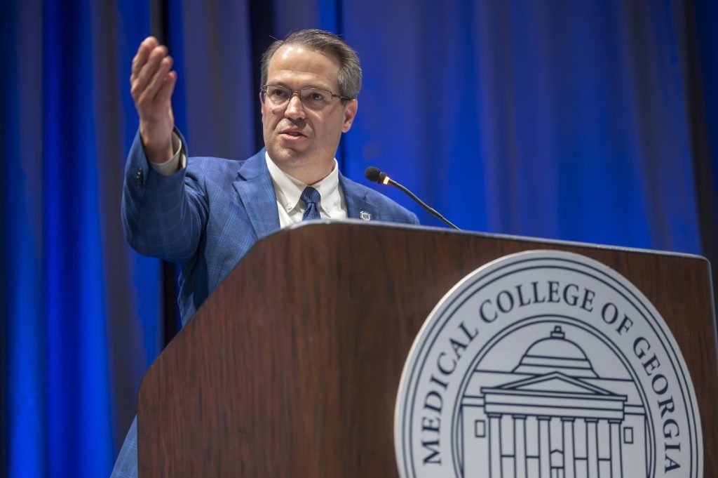 Man standing on stage speaking