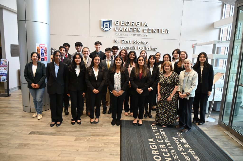 A group photo of male and female high shool students, along with members of the Georgia Cancer Center, posing for a photo after completing the Summer Research Experience 2025.