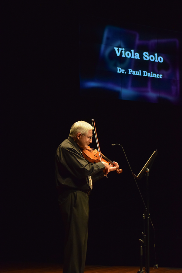 A man playing a viola on stage.