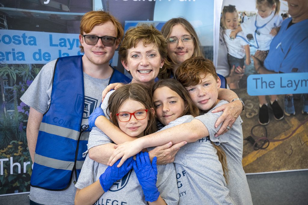 woman hugs children