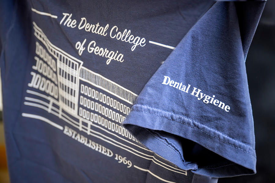 A t-shirt with "The Dental College of Georgia" and a picture of a building on the back. One sleeve has "Dental Hygiene" printed on it.