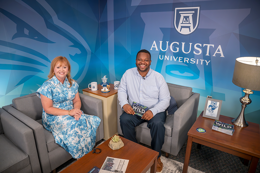 A man and a woman on the set of a podcast.