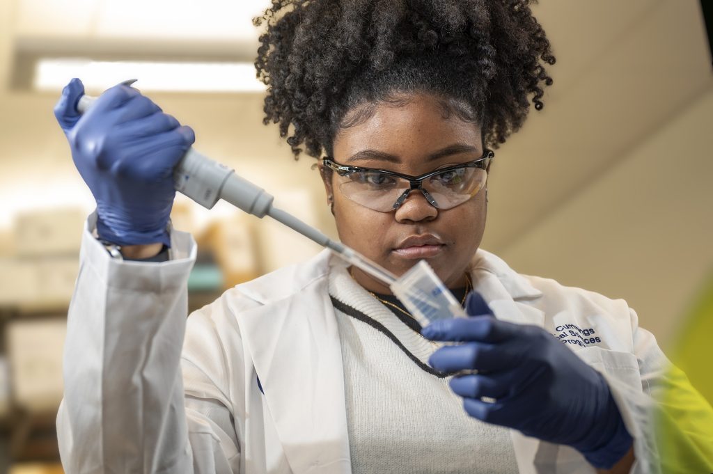 Woman using test tube in science lab