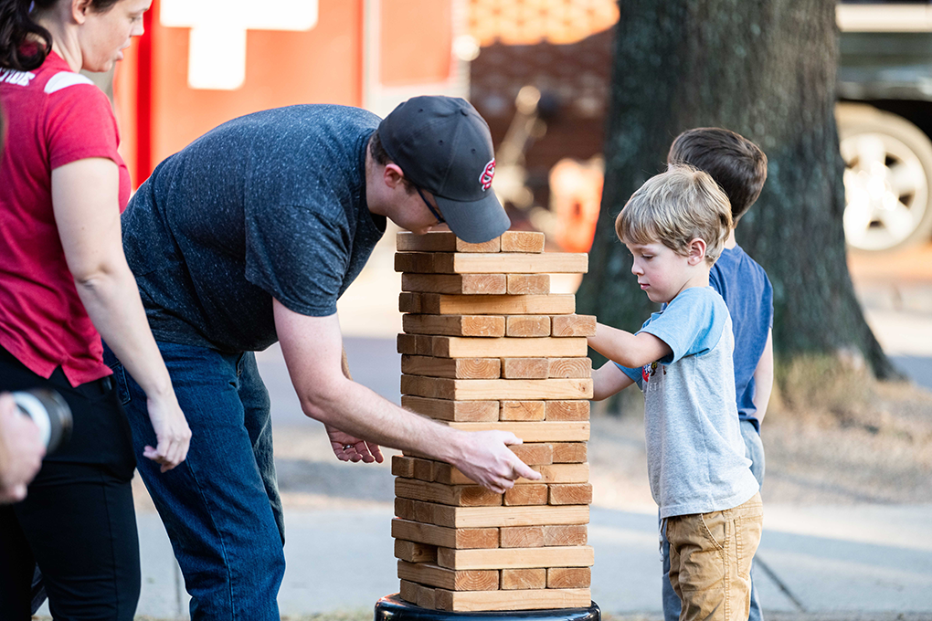 A man and a little boy play a game of giant Jenga at a fundraising event.