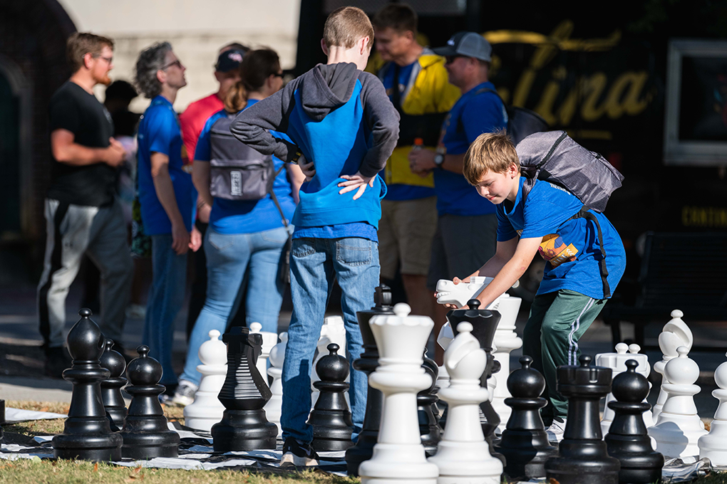 A young boy plays a game of giant Chess at a fundraising event.