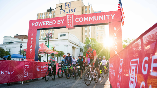 A group of bikers start a race at the starting line.