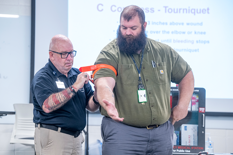 Two men demonstrate how to properly use a Stop the Bleed kit.